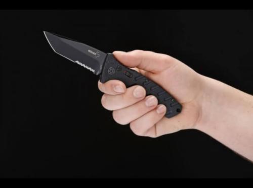 Couteau  lame mixte dans une main sur fond noir
